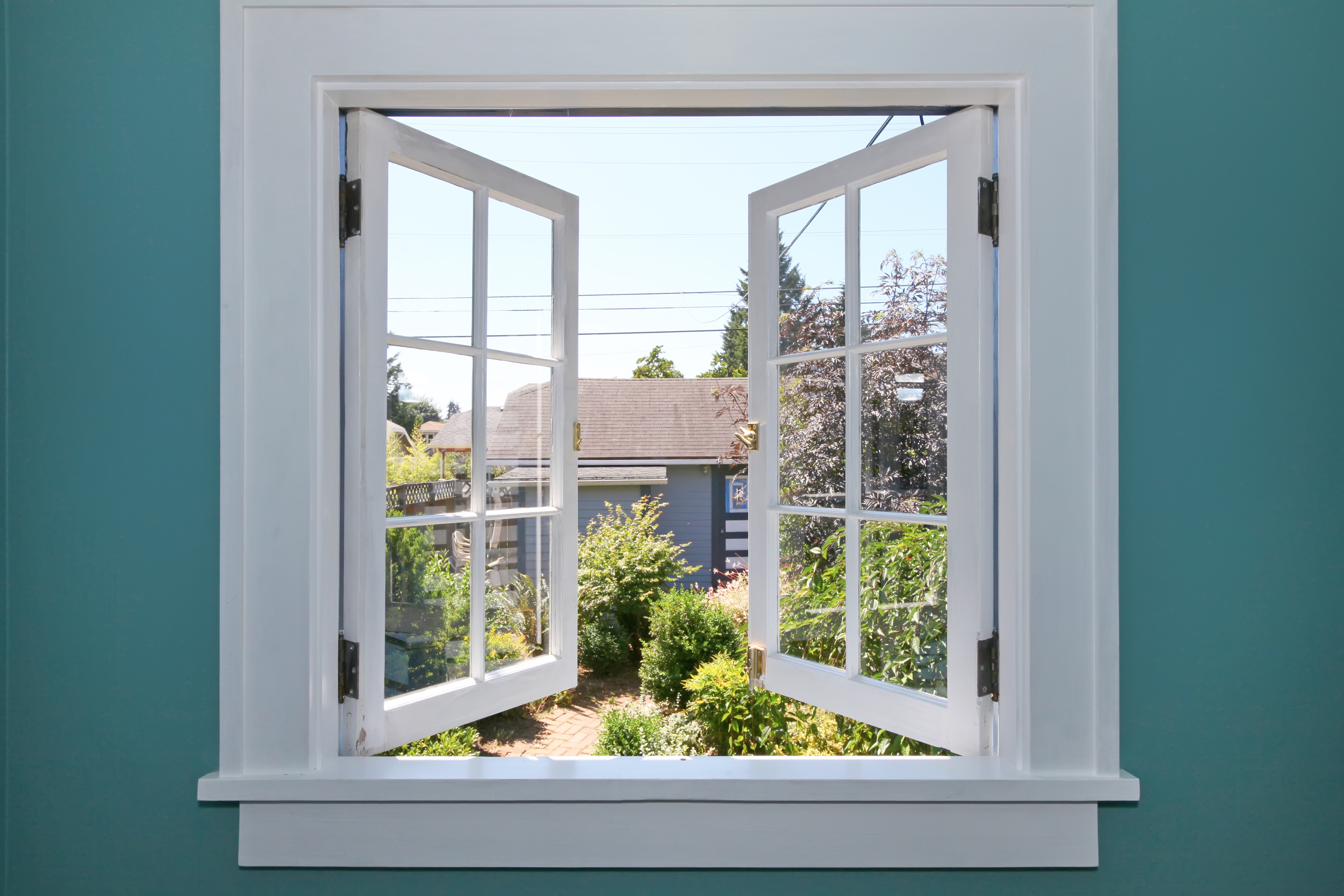 white open window onto a green garden